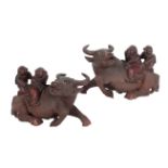 A PAIR OF CHINESE CARVED WOOD GROUPS OF BOYS RIDING BUFFALO