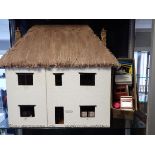 A THATCHED DOLLS HOUSE, IN THE STYLE OF MILTON ABBAS