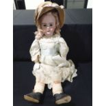 A LARGE BISQUE-HEAD DOLL