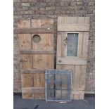 A LEDGED DOOR, OF THREE WIDE BOARDS WITH ROUND APERTURE