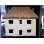 A THATCHED DOLLS HOUSE, IN THE STYLE OF MILTON ABBAS