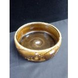 A JAPANESE BROWN-GLAZED POTTERY DISH