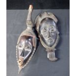 TWO AFRICAN MASKS, ONE SURMOUNTED BY A CHICKEN