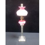 A VICTORIAN OIL LAMP, ON A SILVER CORINTHIAN COLUMN BASE