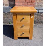 A MODERN THREE-DRAWER LIGHT OAK BEDSIDE CHEST