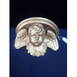 A GILTWOOD AND PLASTER PUTTO WALL BRACKET