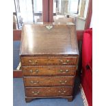 AN OAK AND MAHOGANY CROSSBANDED BUREAU OF SMALL PROPORTIONS