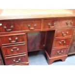 A REPRODUCTION FIGURED MAHOGANY KNEEHOLE DESK