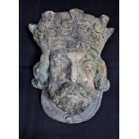 A WEATHERED CAST WALL POCKET, IN THE FORM OF A MEDIEVAL KING