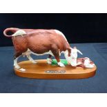 A ROYAL DOULTON HEREFORD COW AND CALF