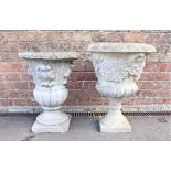 A RECONSTITUTED STONE GARDEN URN WITH FLORAL SWAG DECORATION