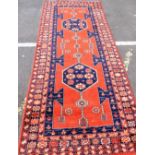 A LONG RED GROUND CAUCASIAN STYLE RUG