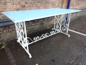 A WROUGHT-IRON FRAMED GARDEN DINING TABLE