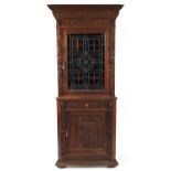 Carved oak corner cupboard with stained glass panel door above a drawer and cupboard door, 220cm