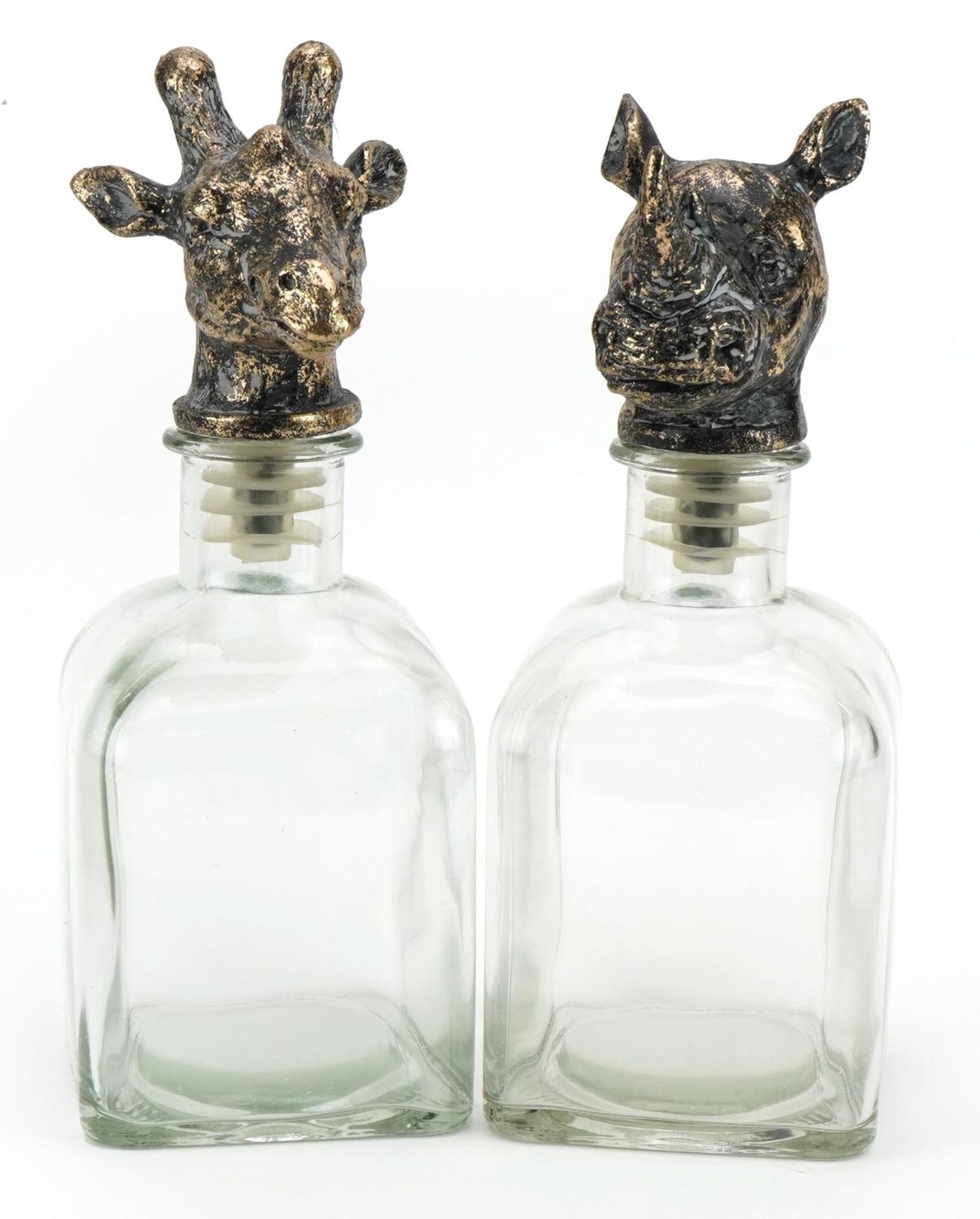 Pair of novelty glass decanters with rhinoceros and giraffe head stoppers, the largest 25cm high