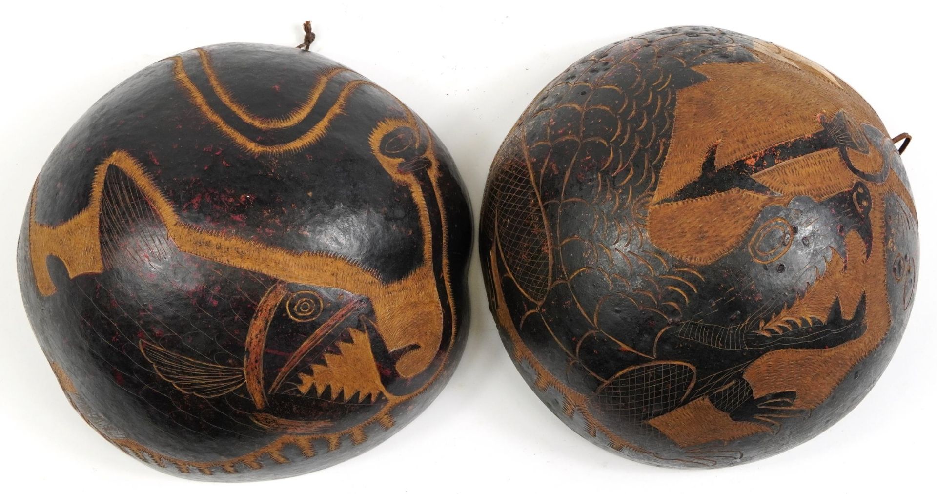 Pair of tribal interest coco de mer bum nut bowls carved with sea creatures, each approximately 23cm