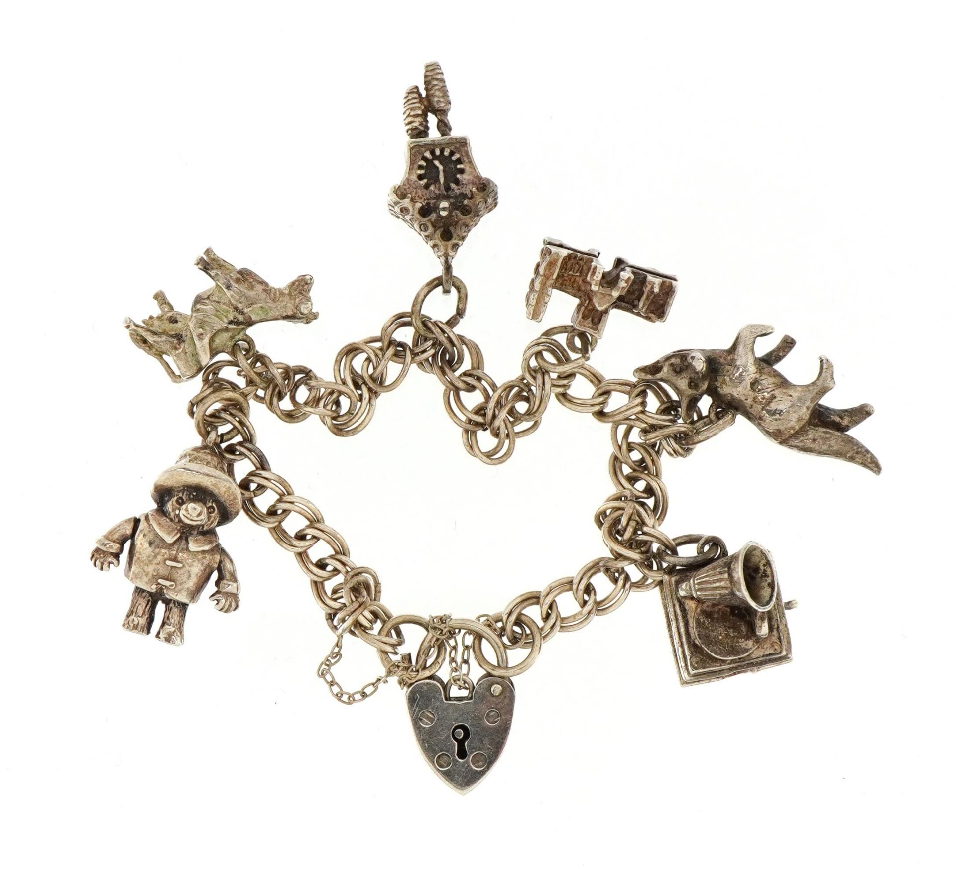 Silver charm bracelet with a selection of mostly silver charms including Paddington Bear with moving