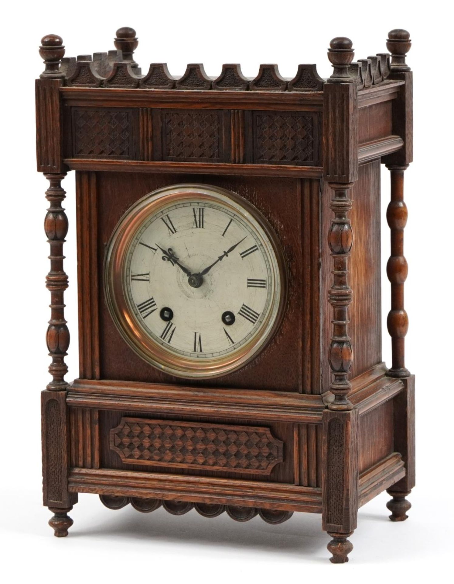 Gothic style carved walnut striking mantle clock with silvered dial having Roman numerals, 35cm high