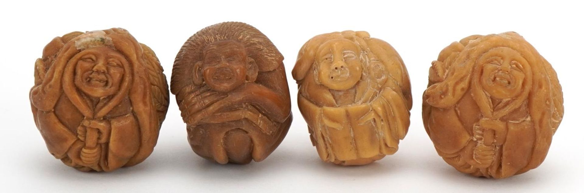 Four Japanese carved nut netsukes of animals and elders, the largest 3.5cm wide