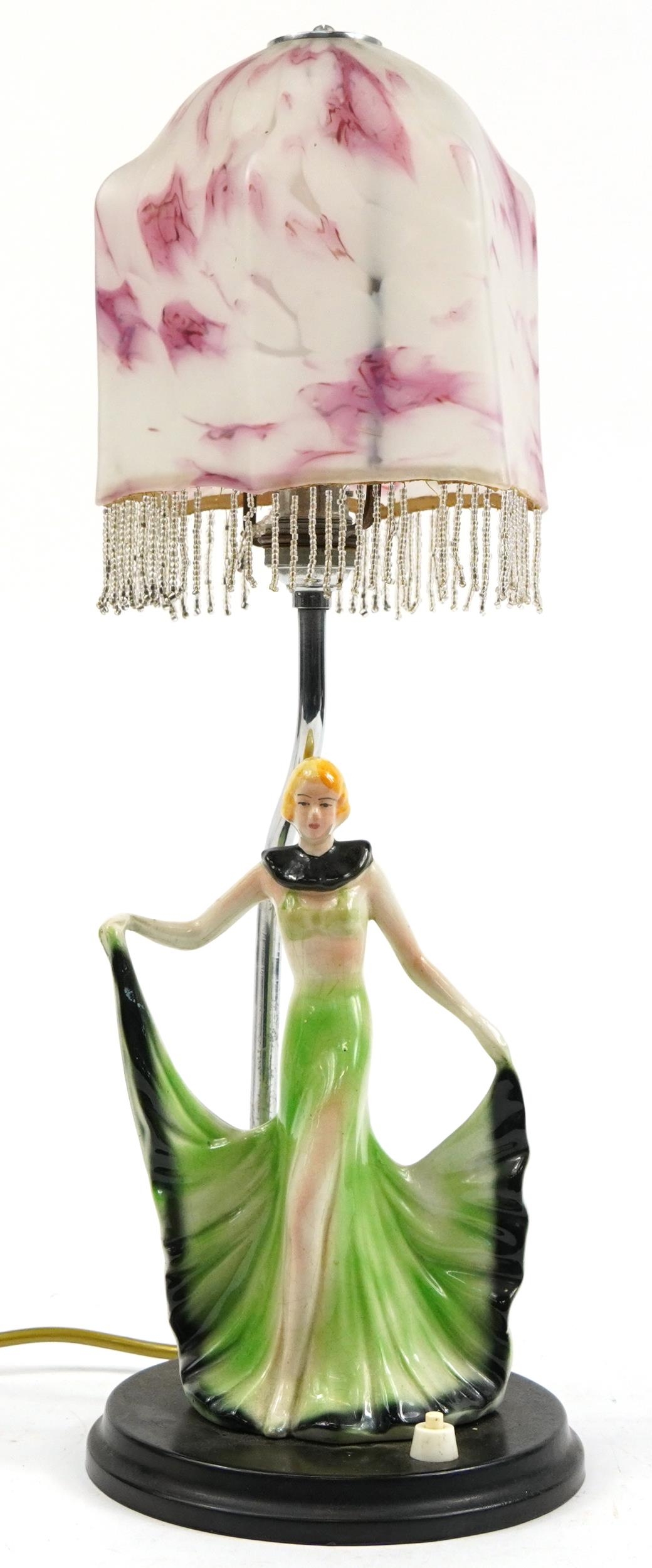 Art Deco porcelain female dancer table lamp with pink and white mottled glass shade, 48cm high