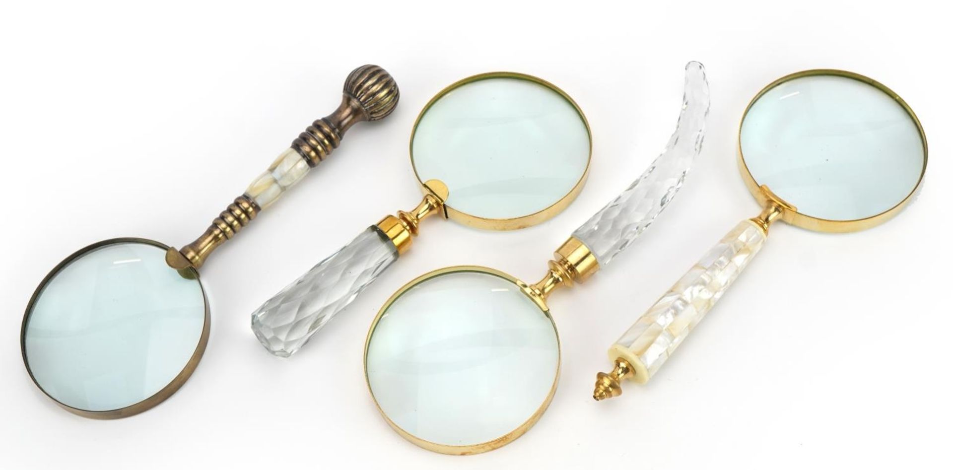 Three large magnifying glasses, two with mother of pearl handles, the largest 26cm in length