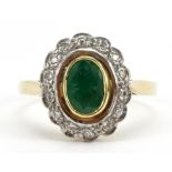 18ct gold emerald and diamond cluster ring, the emerald approximately 6.7mm x 4.6mm, London 1988,