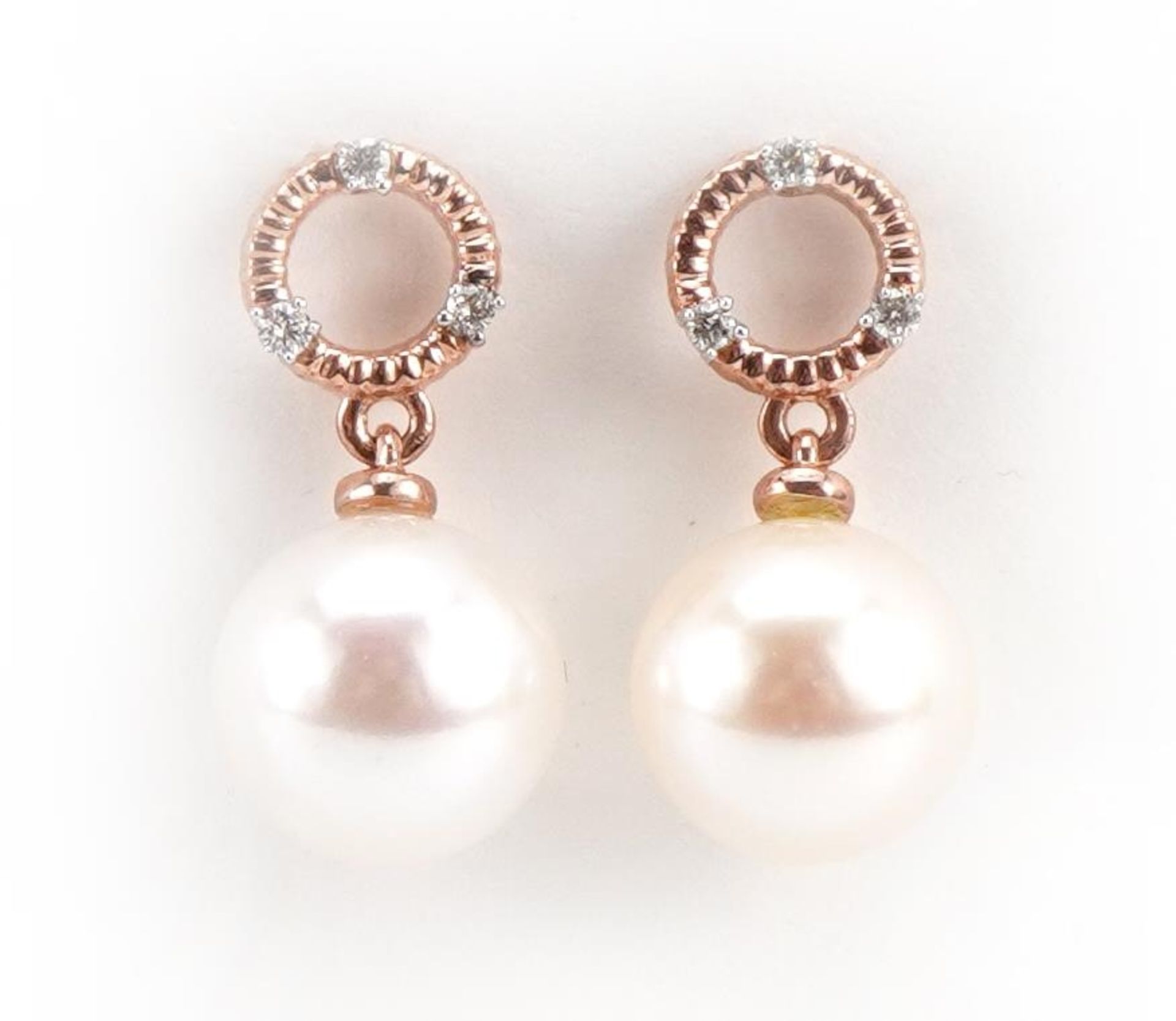 Pair of 9ct rose gold pearl drop earrings, each set with three diamonds, total diamond weight