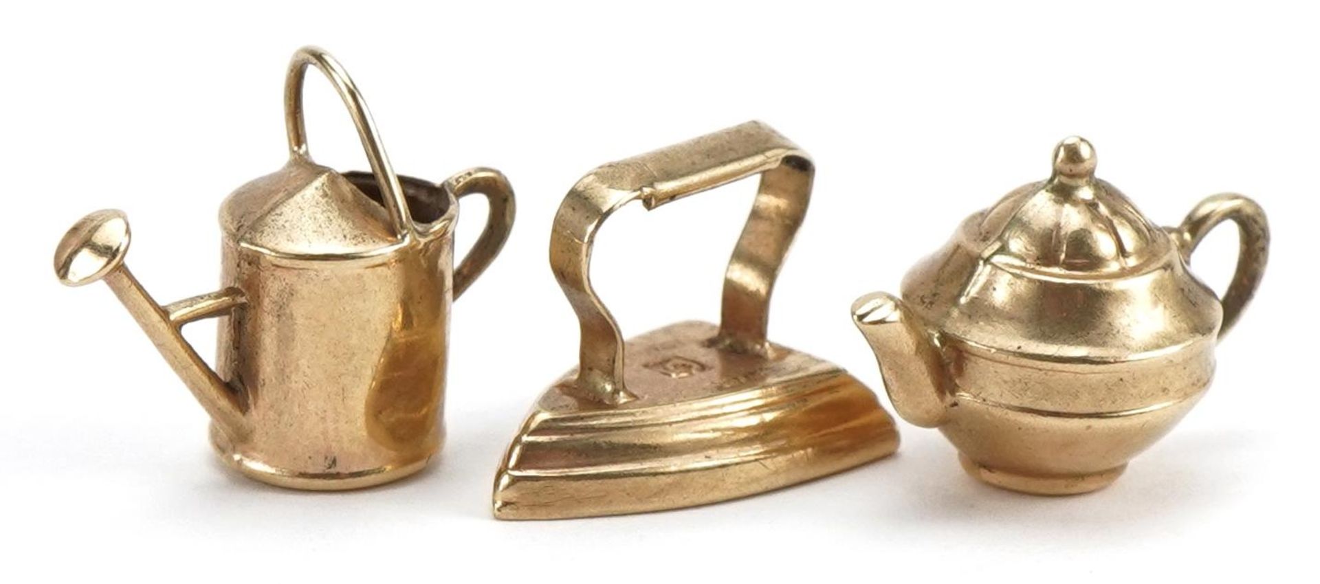 Three 9ct gold charms comprising iron, watering can and teapot, the largest 1.3cm high, total 2.0g