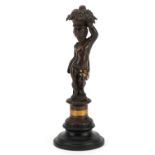 French patinated bronze lustre in the form of a cherub raised on a circular ebonised base, 20cm high