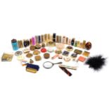 Collection of vintage vanity objects including lipstick cases and compacts