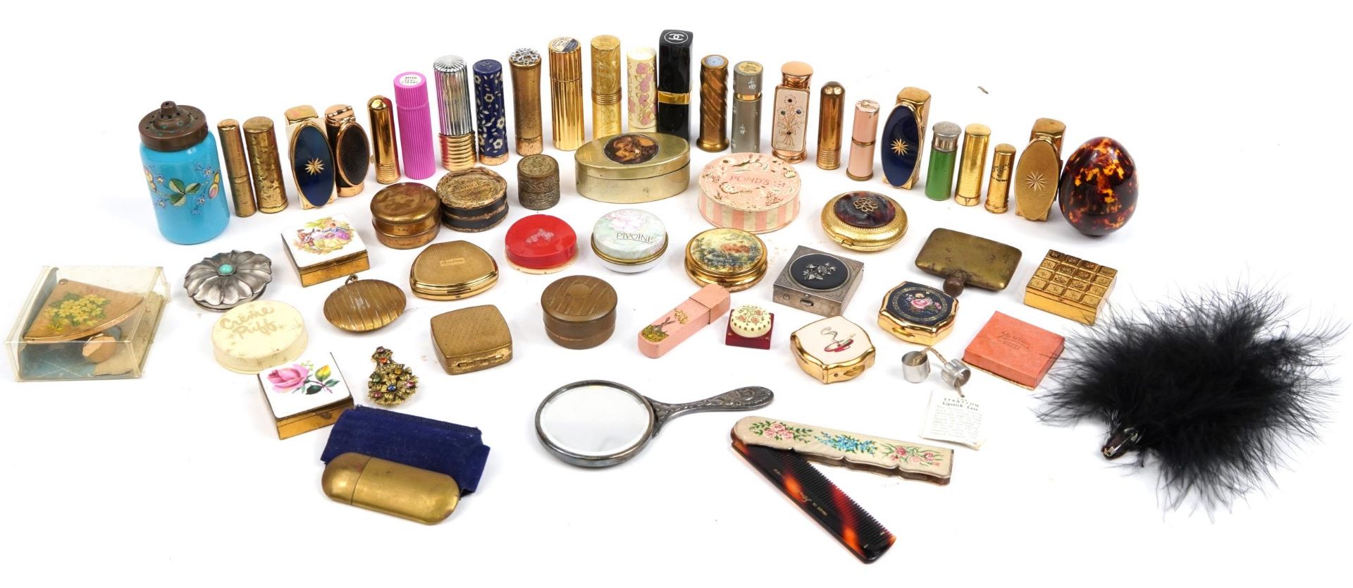 Collection of vintage vanity objects including lipstick cases and compacts