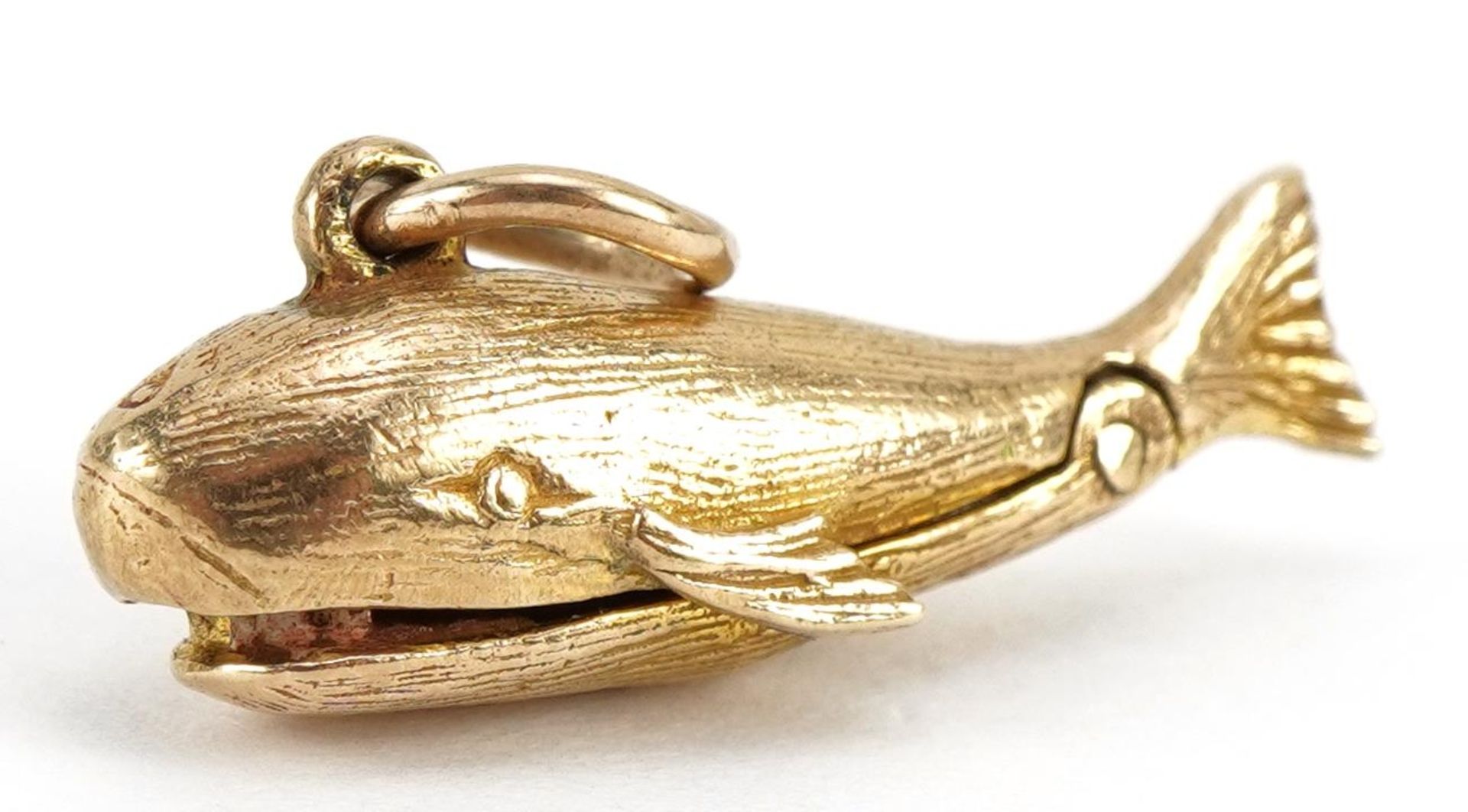 9ct gold whale charm with hinged mouth opening to reveal an enamelled figure, 2.3cm wide, 2.7g