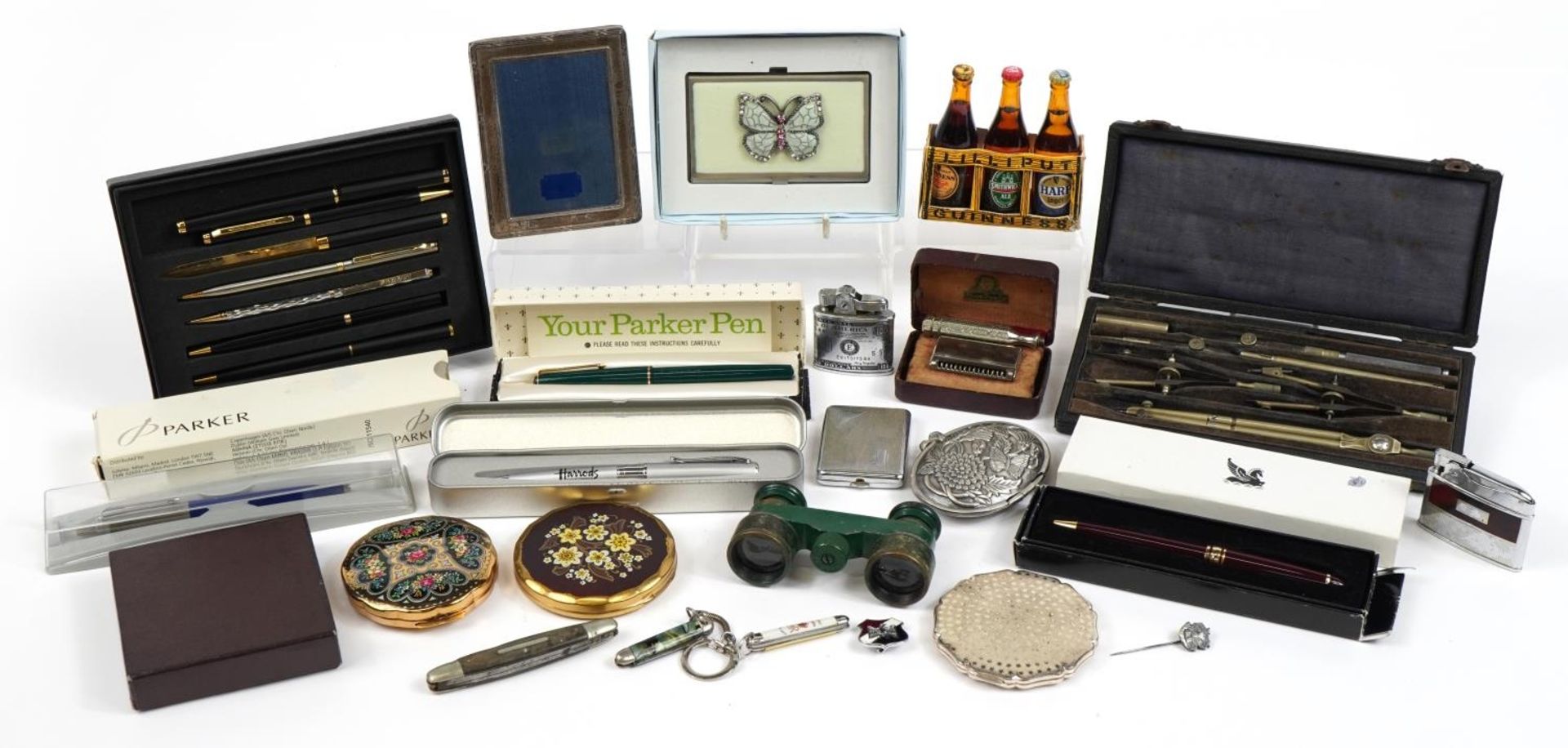 Objects including compacts, folding pocket knives, pens and a miniature silver easel photo frame