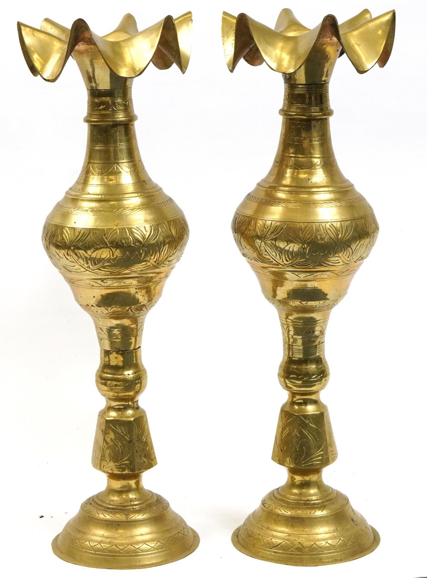 Pair of Indian floor standing brass vases with frilled rims engraved with flowers, each 76.5cm high