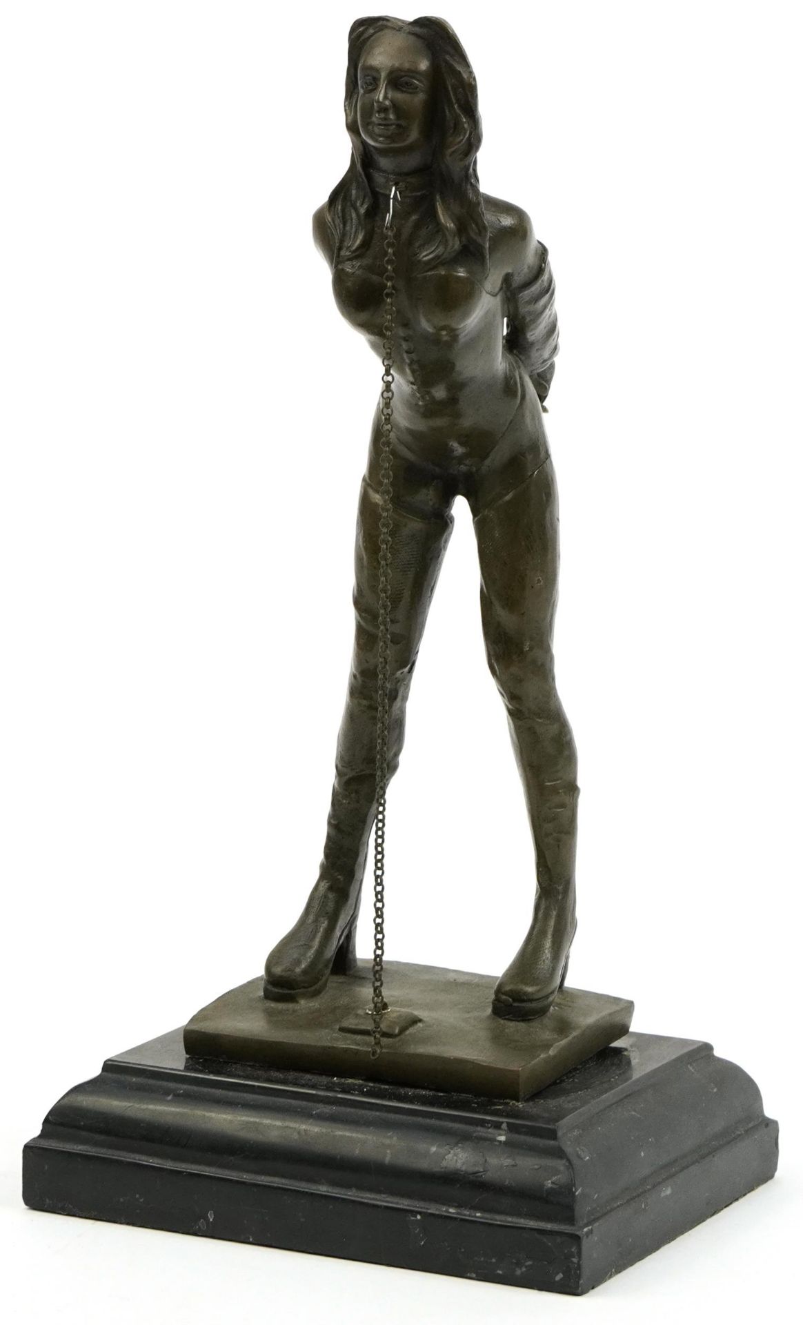 Patinated bronze figure of a dominatrix raised on black slate base, 32cm high