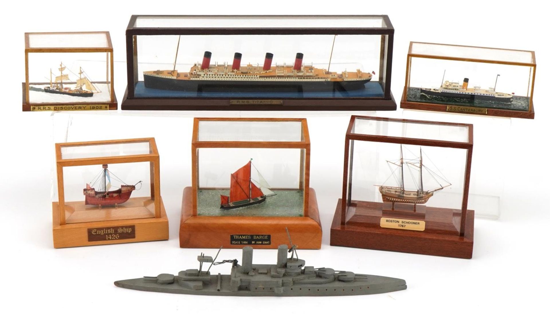 Seven miniature hand painted wooden model ships by John Evans, six with display cases, the largest