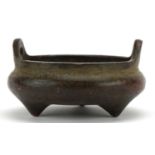 Miniature Chinese patinated bronze censer with twin handles raised on three feet, character marks to