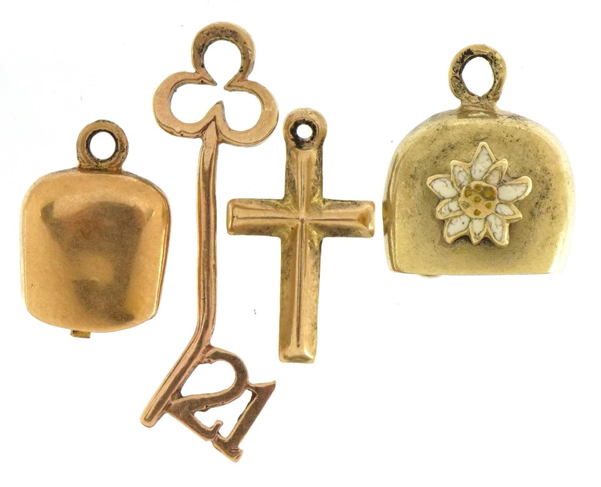 Four 9ct gold charms including bell with enamelled flower, '21' key and cross, the largest 2.5cm