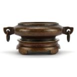 Chinese patinated bronze twin handled censer on stand, four figure character marks to the base, 15cm
