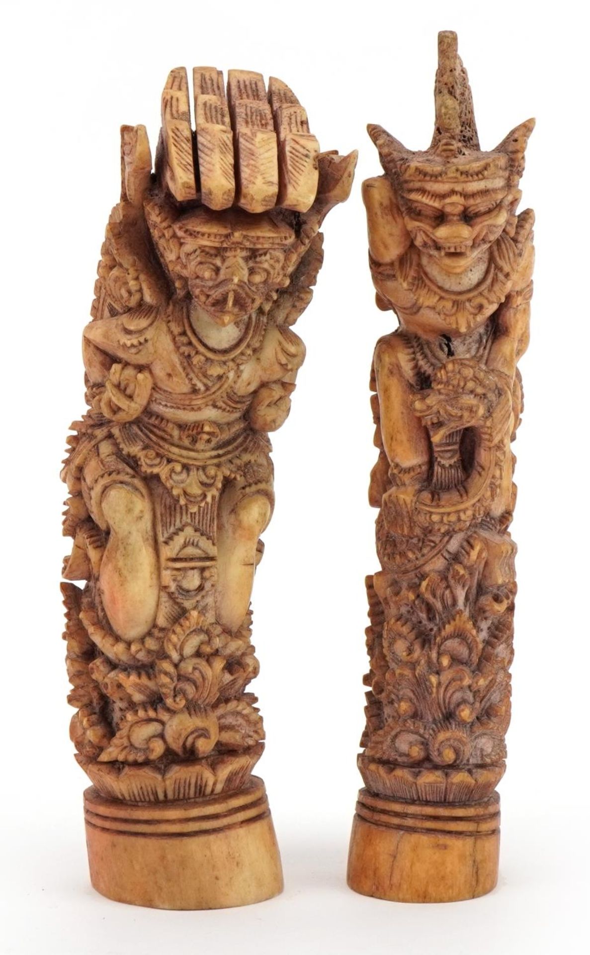 Two Burmese carved bone mythical figures, one with a serpent, the largest 16cm high