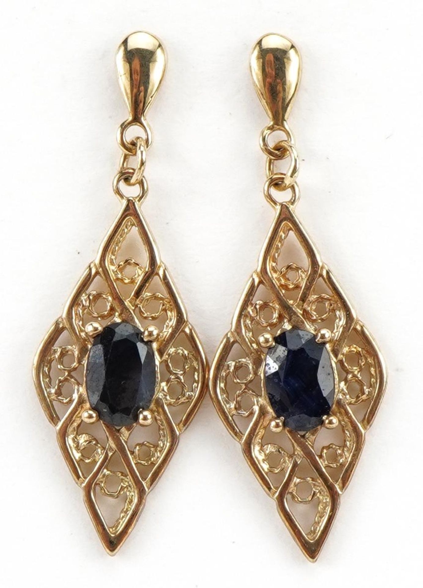 Pair of unmarked gold open work drop earrings, each set with a sapphire, 3.1cm high, 1.9g