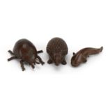 Three Japanese patinated bronze animals comprising hedgehog, beetle and fish, each with impressed