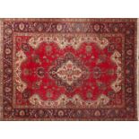 Hand made Iranian carpet with stylised floral pattern onto a red and blue ground, 354cm x 254cm