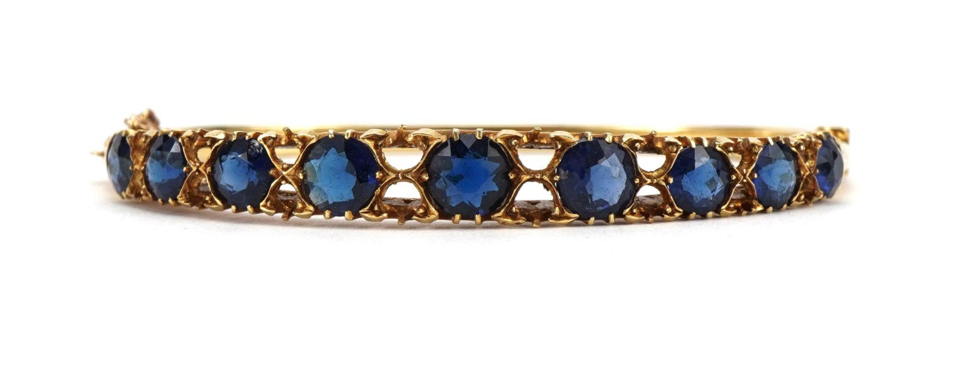 Victorian 15ct gold hinged bangle set with nine graduated blue stones, 6.5cm wide, 14.5g