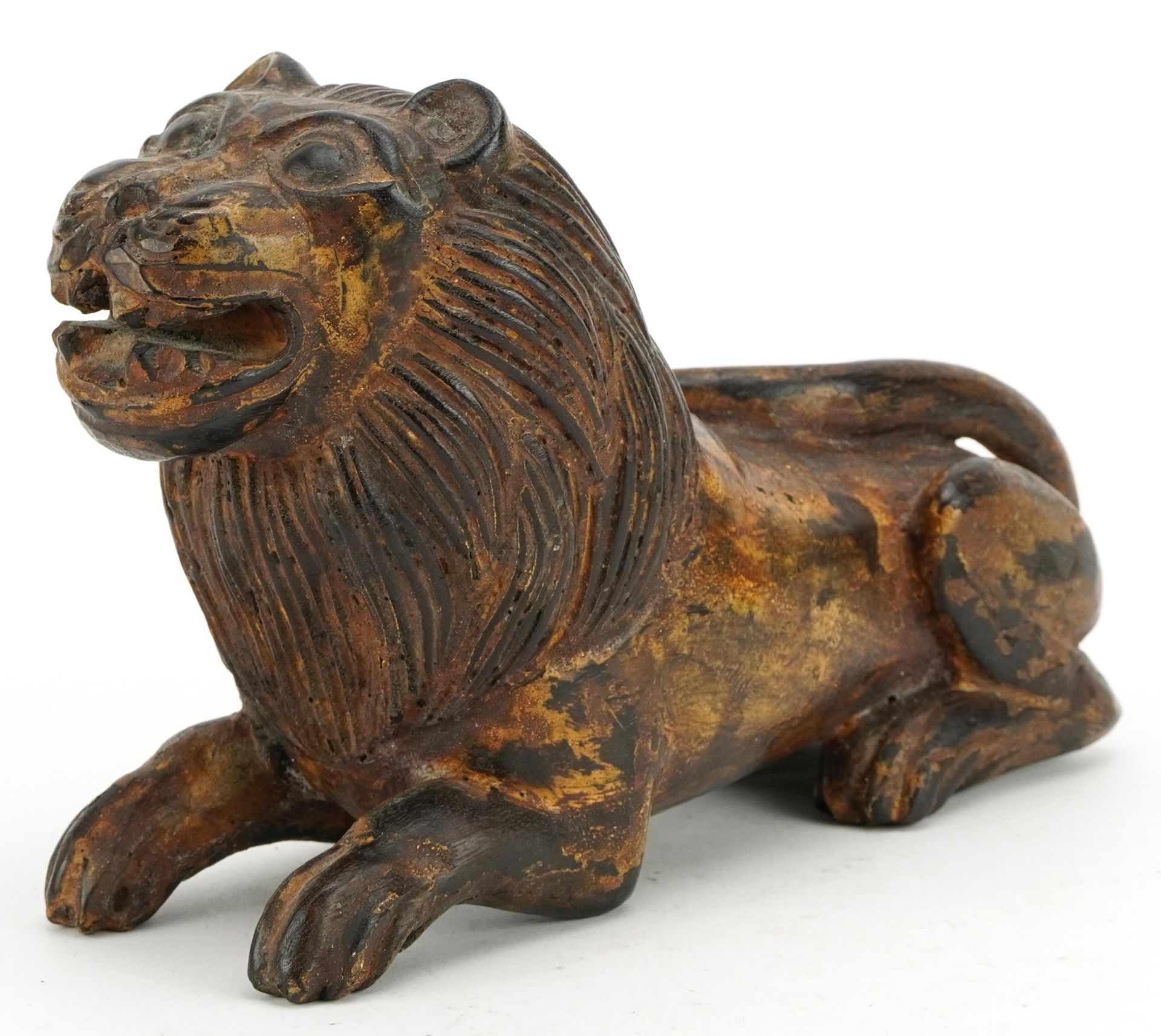Chinese carved hardwood lion with remnants of paint, 26cm in length