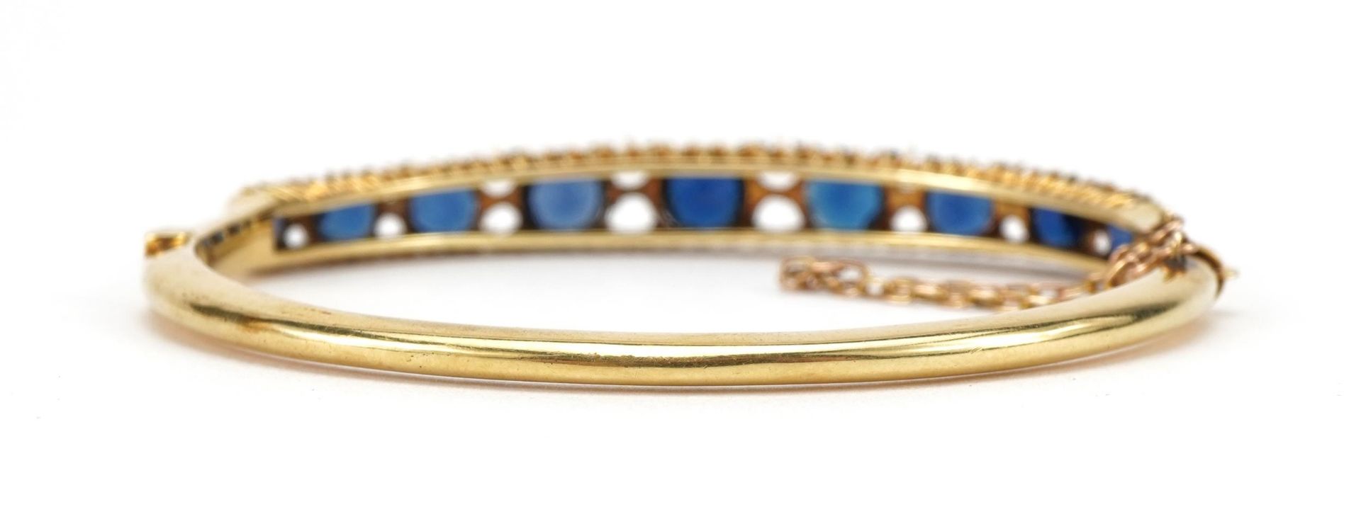 Victorian 15ct gold hinged bangle set with nine graduated blue stones, 6.5cm wide, 14.5g - Bild 2 aus 3