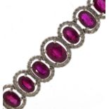 Impressive 18ct white gold graduated ruby and diamond halo bracelet, total ruby weight approximately