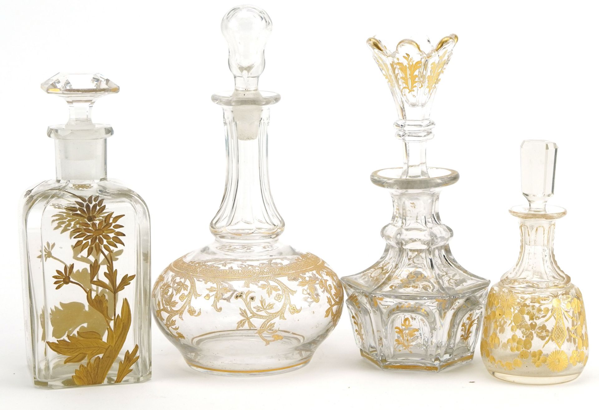 Four 19th century French glass decanters with gilt decoration, the largest 17.5cm high