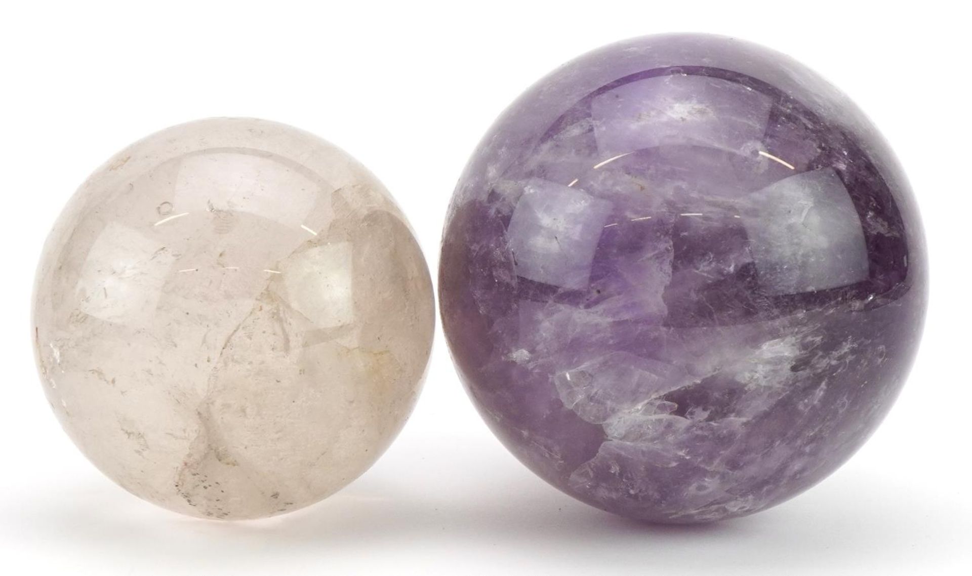 Two crystal balls including an amethyst example, the largest 11cm in diameter