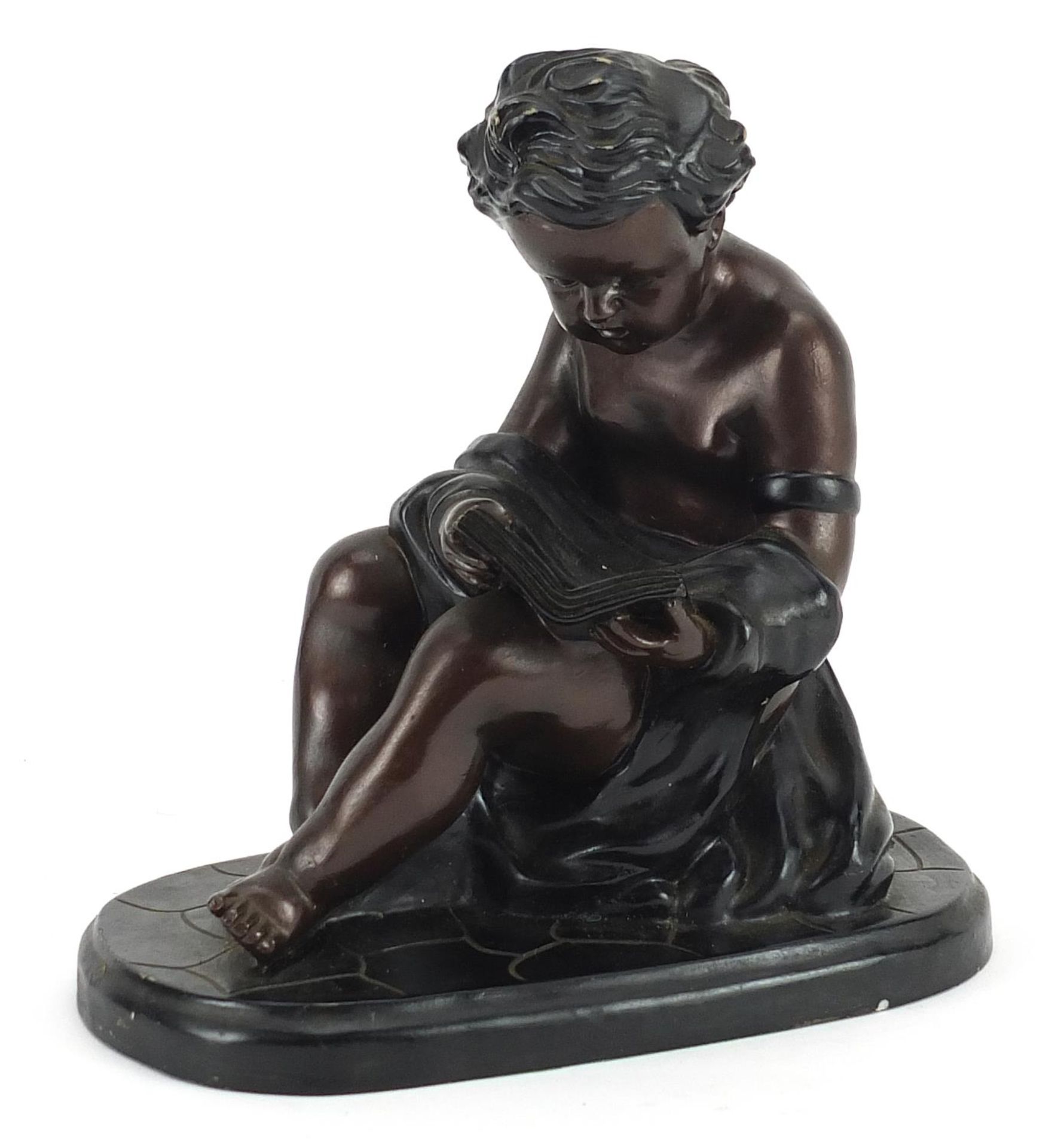 Bronzed figure of a young child reading a book, 17.5cm high